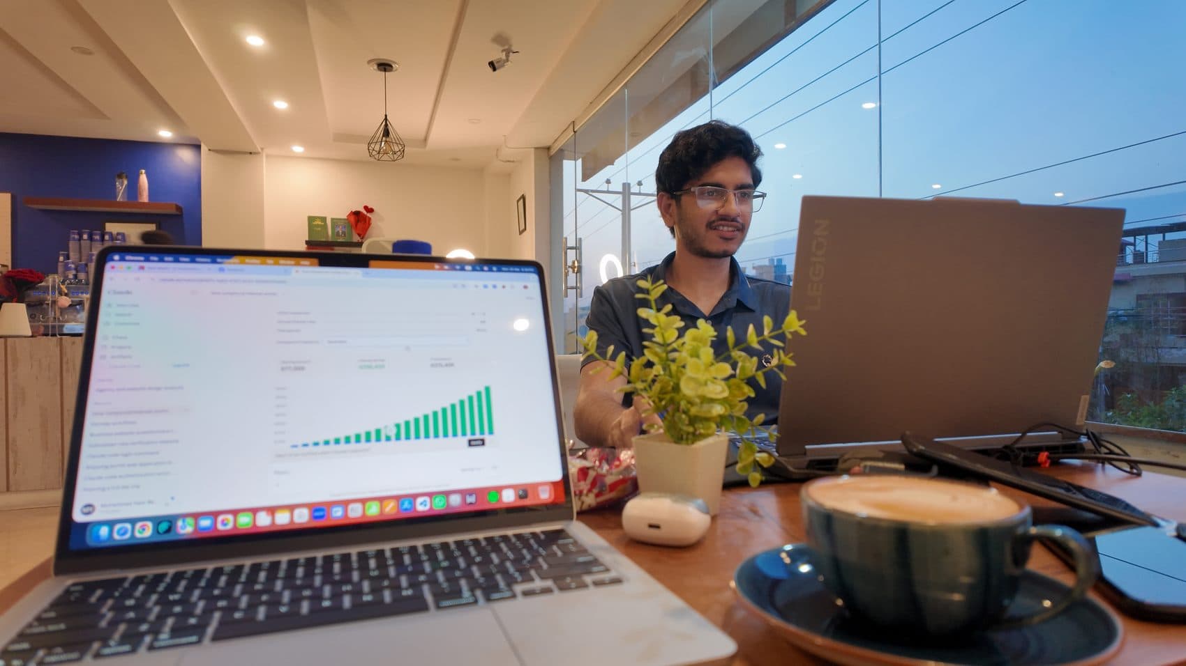 Dual laptops with an analytics dashboard over coffee